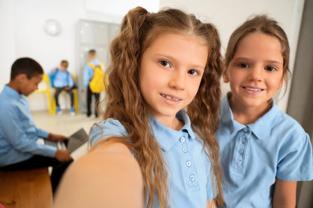 Little girls taking selfie at school hall, closeupの写真素材