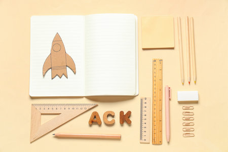 Cardboard rocket with different school stationery on beige backgroundの写真素材