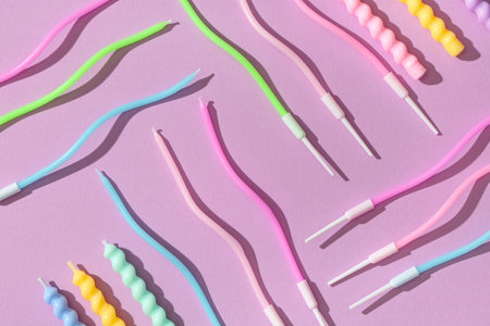 Many colorful birthday candles on lilac backgroundの写真素材