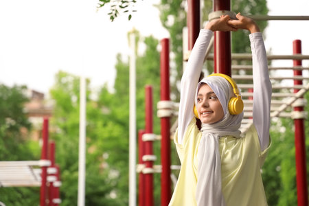 Sporty Muslim woman in headphones training outdoorsの写真素材
