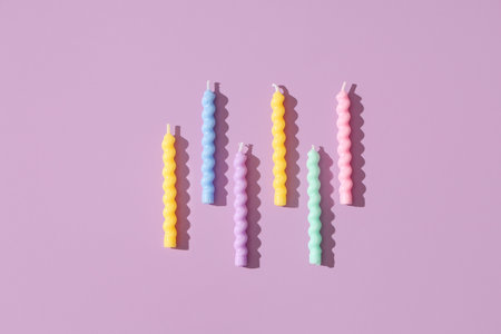 Colorful Birthday candles on lilac backgroundの写真素材