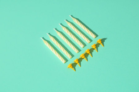 Many yellow birthday candles on turquoise background