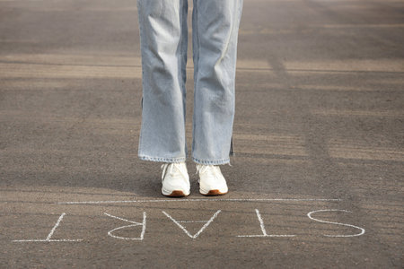 Woman standing on asphalt road with the word START. Concept of new beginning