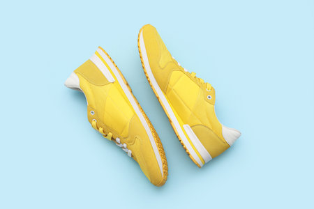 Stylish male yellow sneakers on blue backgroundの写真素材