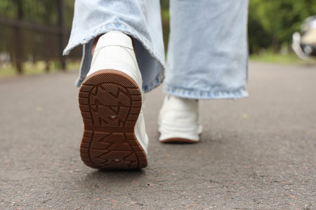 Woman walking along road, closeup. Concept of new beginning