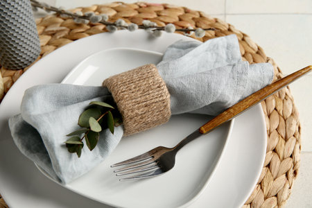 Beautiful table setting with eucalyptus and willow branch on white tile backgroundの写真素材