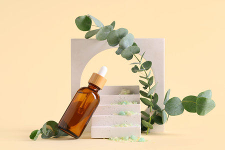 Plaster stands and bottle of eucalyptus essential oil on beige background