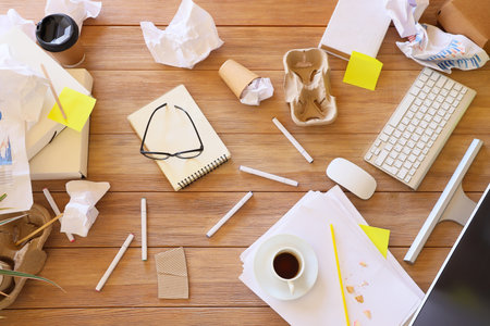 Messy workplace with stationery and garbage in office, top viewの写真素材
