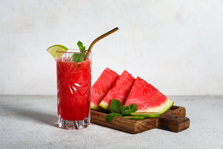 Glass of fresh watermelon juice with lime and mint on white backgroundの写真素材