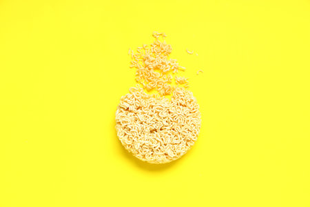 Raw instant noodles on yellow backgroundの写真素材