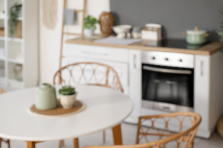 Blurred view of light kitchen with counters and dining tableの写真素材