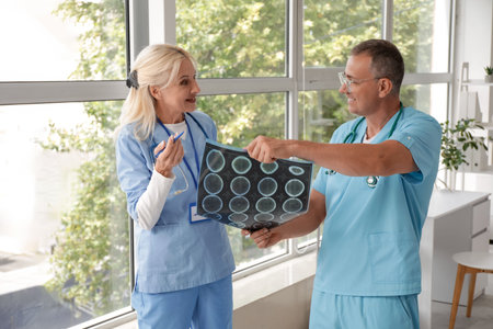 Mature doctors studying MRI scan in clinic