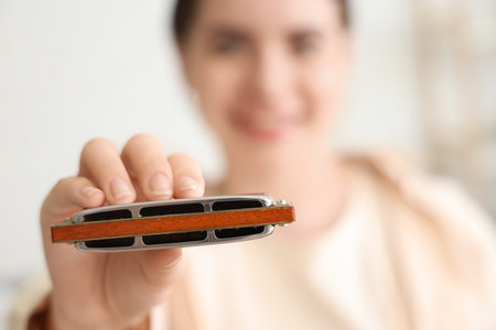 Young woman with harmonica at home, closeup