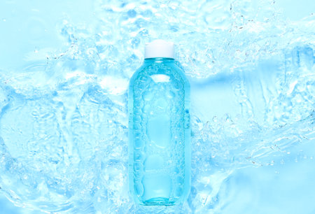 Bottle of micellar water on wet blue background, closeupの写真素材