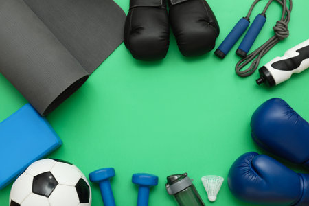Frame made of sport equipment with soccer ball and jump rope on green background. Top viewの写真素材