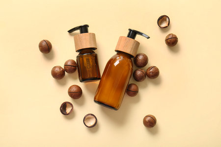 Macadamia nuts and bottles of cosmetic product on beige backgroundの写真素材
