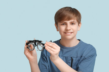 Little boy with optical trial frame on blue background