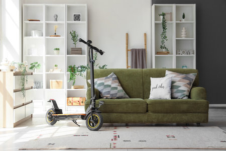 Interior of living room with electric scooter, sofa and shelf unitsの写真素材