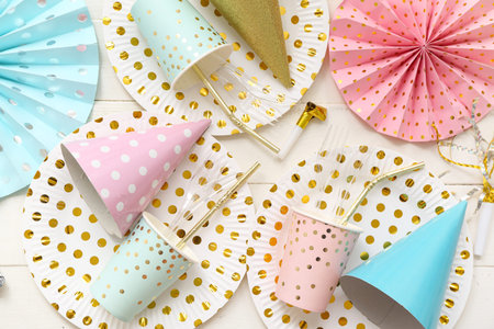 Composition with paper disposable tableware and decor for birthday party on light wooden backgroundの写真素材