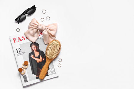 Composition with magazine, hair brush and stylish female accessories on light backgroundの写真素材