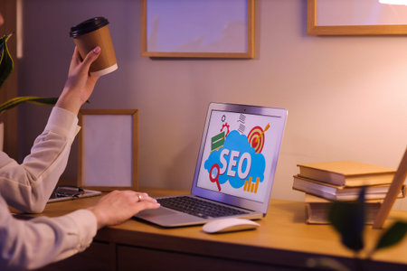 Woman using laptop with abbreviation SEO in dark office