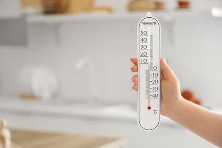 Woman with home thermometer in kitchen, closeupの写真素材