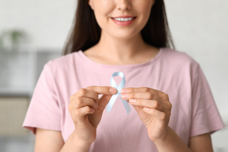 Diabetic young woman with blue awareness ribbon at home, closeup