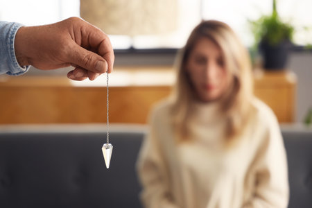 Male hypnotist with pendulum in office, closeup