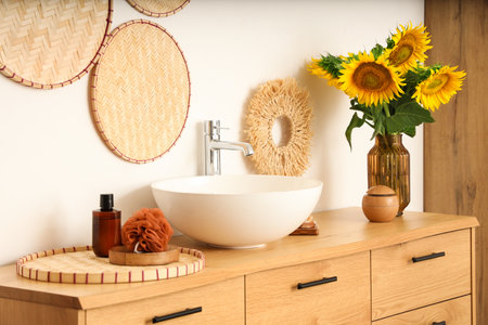 Vase with beautiful sunflowers on wooden cabinet in bathroomの写真素材