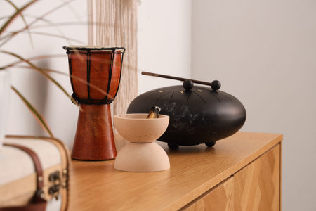 Bowl with Palo Santo, drum and glucophone on commode in room, closeup
