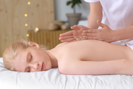 Young woman enjoying massage in spa salonの写真素材
