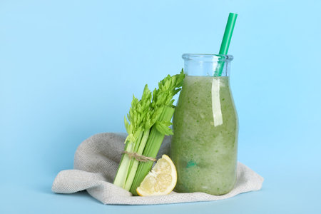 Bottle of celery juice with celery and lemon on blue backgroundの写真素材