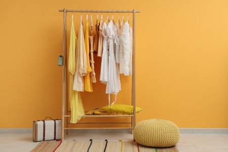 Rack with female clothes near yellow wallの写真素材