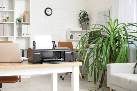 Modern printer on wooden table in stylish office