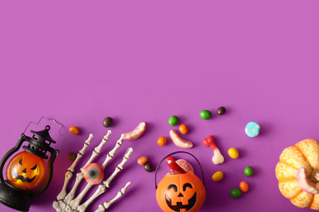 Composition with decorations and treats for Halloween on purple backgroundの写真素材