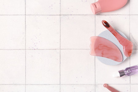 Plaster stand, bottles of cosmetic product and facial massage tools on tile backgroundの写真素材