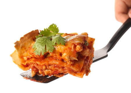 Spatula with piece of tasty enchilada on white backgroundの写真素材