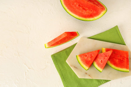 Board with pieces of sweet watermelon on white background