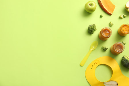 Composition with healthy baby food, ingredients and accessories on green backgroundの写真素材
