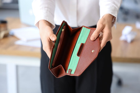 Bankrupt businesswoman with empty wallet in office, closeup