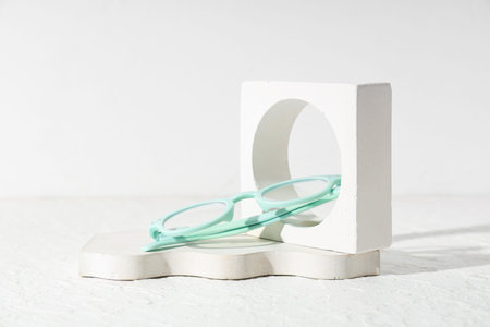 Composition with eyeglasses and plaster podiums on white background