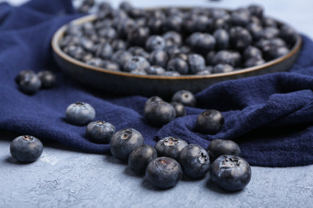 Plate with sweet fresh blueberries on blue backgroundの写真素材