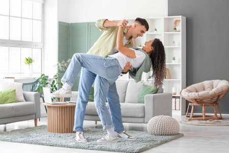 Happy young beautiful couple dancing at home