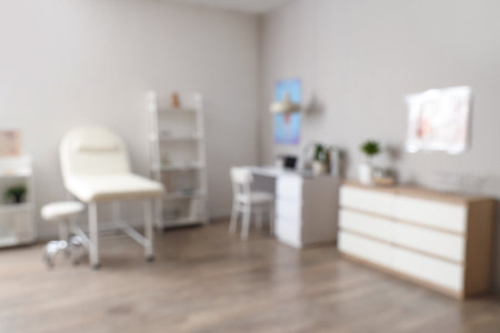Blurred view of medical office with couch, shelf units and doctor's workplaceの写真素材