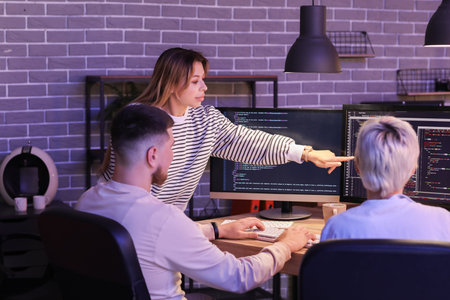 Female programmer with her colleagues working in office at night