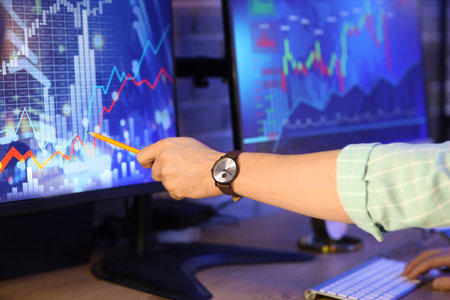 Male trader working in office at night, closeup