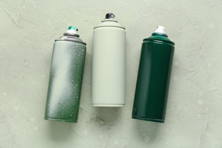 Spray paint cans on green grunge backgroundの写真素材
