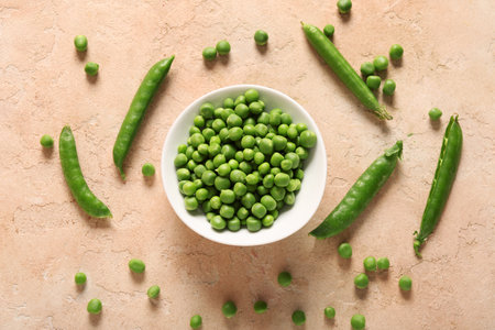 Bowl of green peas on beige backgroundの写真素材