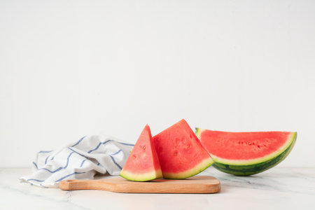 Wooden board with pieces of sweet watermelon on white backgroundの写真素材