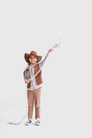 Cute little cowboy with lasso on light backgroundの写真素材